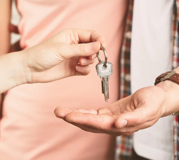 Agente imobiliário dando chaves para jovem casal — Fotografia de Stock