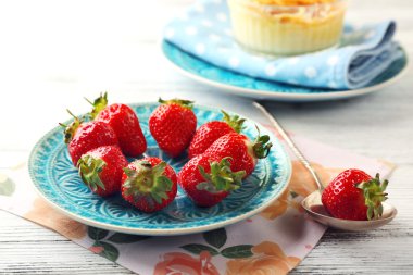 Creme brulee tatlısı peçeteye renk ahşap arka plan üzerinde taze çilek Çilek ile