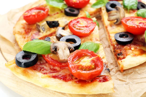 Gustosa pizza con verdure e basilico sul tagliere da vicino — Foto Stock