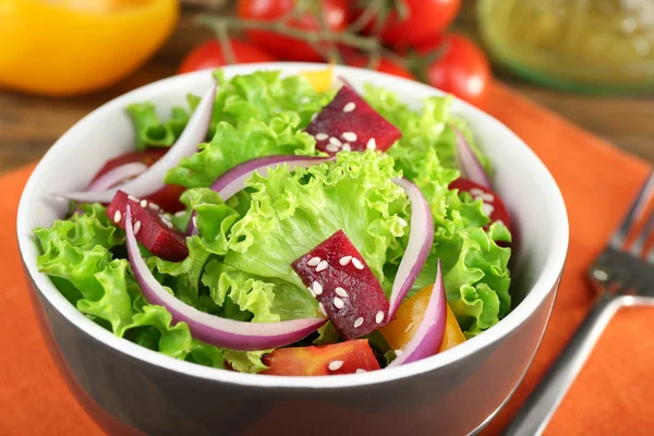 Skål med färsk grönsallad på bord med Servett, närbild — Stockfoto