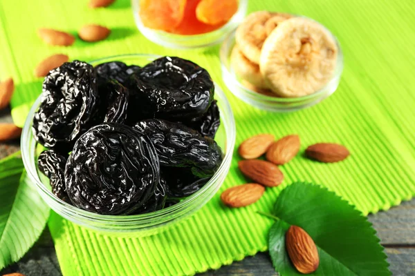 Dried fruits and almonds with leaves on green napkin, closeup — Stock Photo, Image