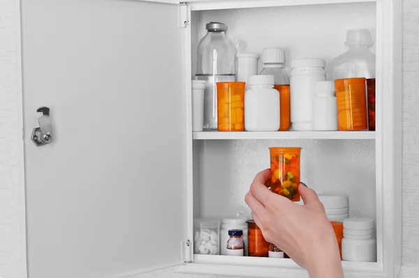 Female hand taking pills from medicine chest, closeup — Stock Photo, Image