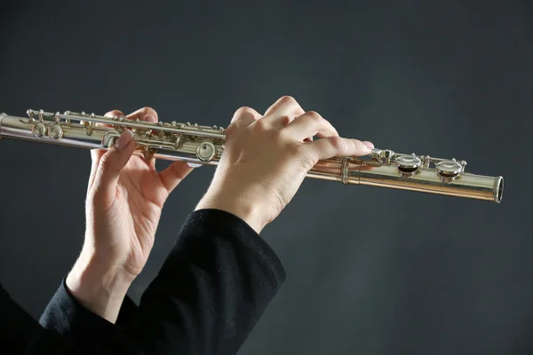 Músico tocando flauta no fundo escuro — Fotografia de Stock