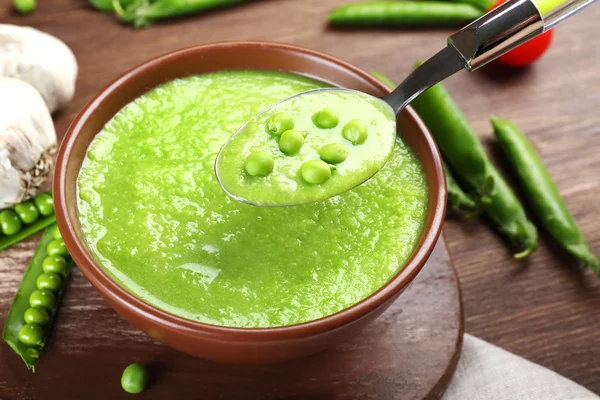 Tasty peas soup and vegetables on table close up — Stock Photo, Image