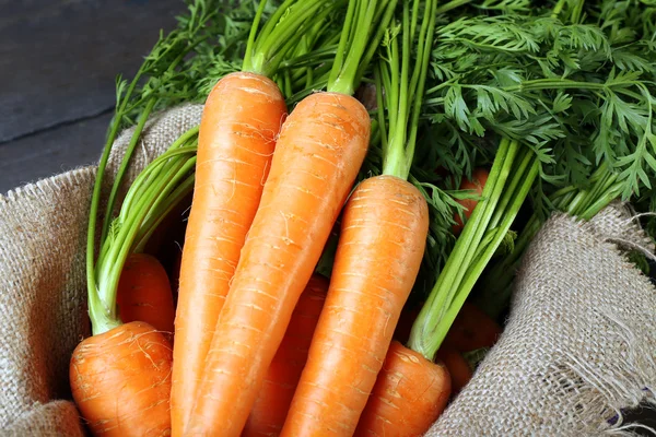 Fresh organic carrots on sackcloth, closeup — Stock Photo, Image