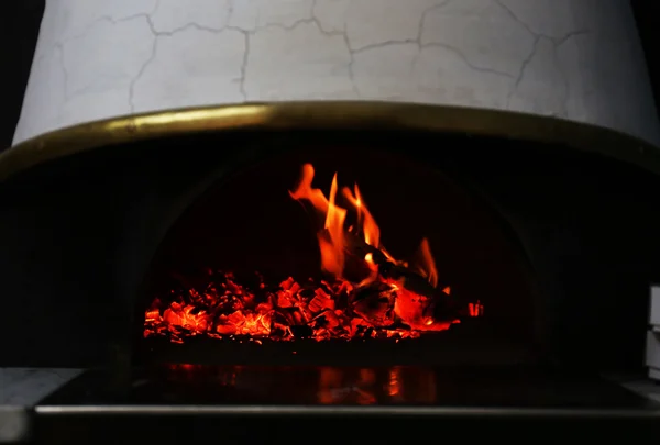Burning firewood in traditional oven at restaurant kitchen — Stock Photo, Image