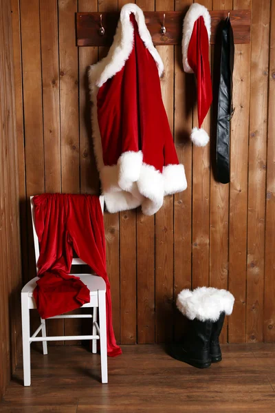 Traje de Santa colgando en fondo de pared de madera — Foto de Stock