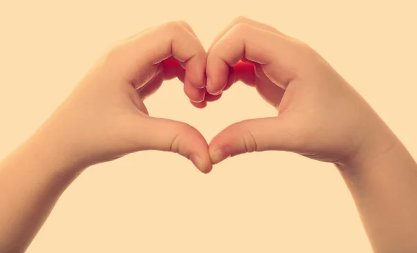 Corazón formado por manos de niño aisladas en blanco sobre fondo claro —  Fotos de Stock