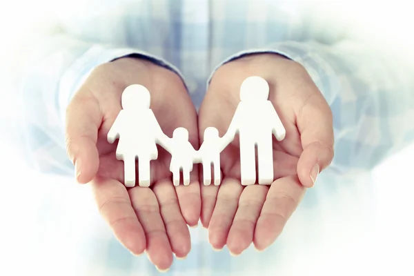 Female hands holding toy family — Stock Photo, Image