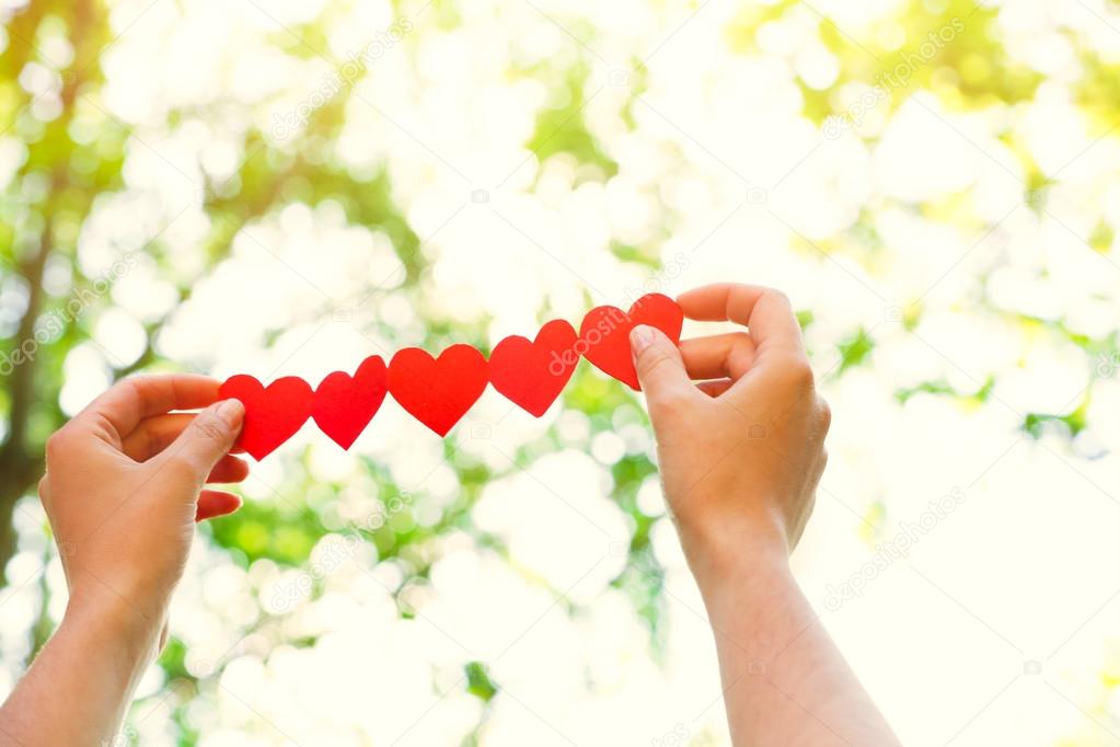 Female hands with chain of paper hearts