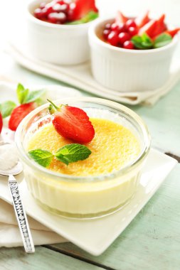 Creme brulee tatlısı peçeteye renk ahşap arka plan üzerinde taze çilek Çilek ile