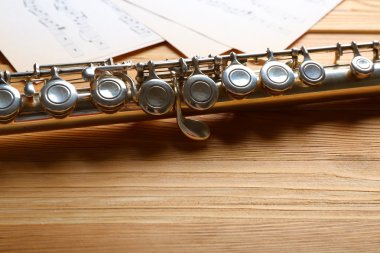 Ahşap masa üzerine müzik notlar ile gümüş flüt yakın çekim