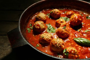 Ahşap arka plan üzerinde domates soslu köfte ile pan