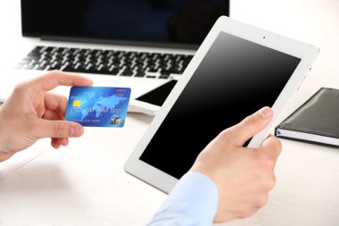 Kredi kartı ve tablet tutan adam