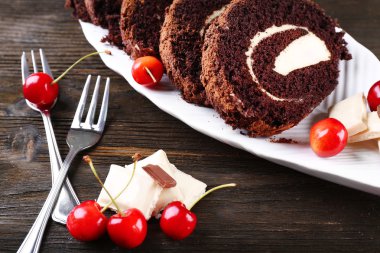 Lezzetli çikolata rulo beyaz tabak içinde ahşap masa, portre