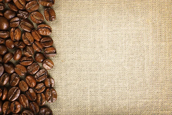 Rahmen aus Kaffeebohnen auf farbigem Sacktuch Hintergrund — Stockfoto