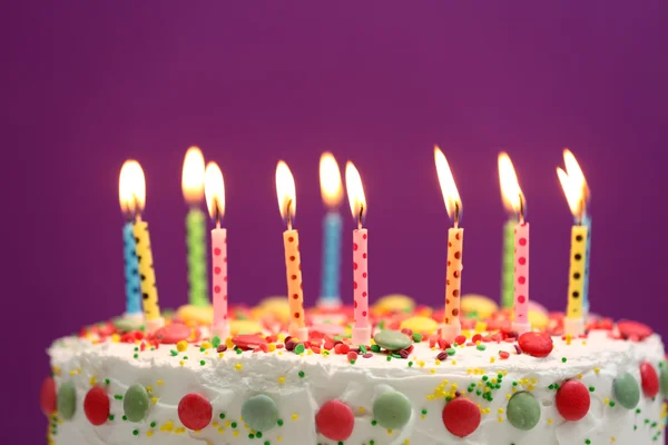 Birthday cake with candles on purple background — Stock Photo, Image