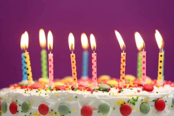 Torta di compleanno con candele su sfondo viola — Foto Stock