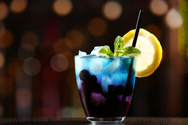 Glass of cocktail in bar on bright blurred background — Stock Photo, Image