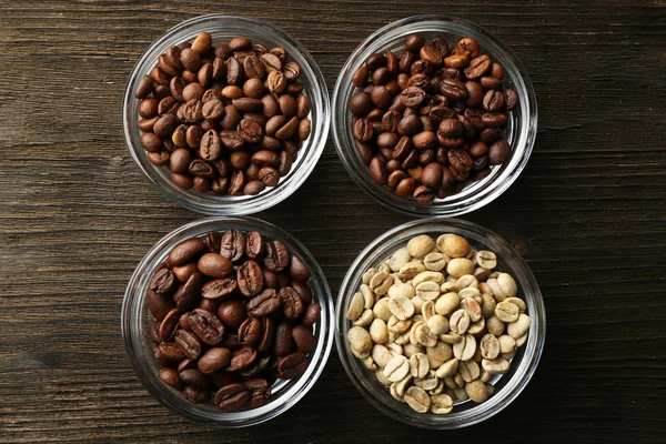 Coffee beans in saucers on wooden background — Stock Photo, Image