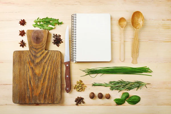 Open receptenboek met verse kruiden en specerijen op houten achtergrond — Stockfoto