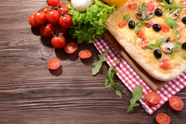 Leckere hausgemachte Pizza auf dem Tisch aus nächster Nähe — Stockfoto