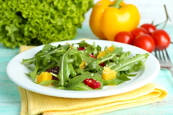 Salad lezat dengan daun arugula di piring di atas meja kayu, closeup — Stok Foto