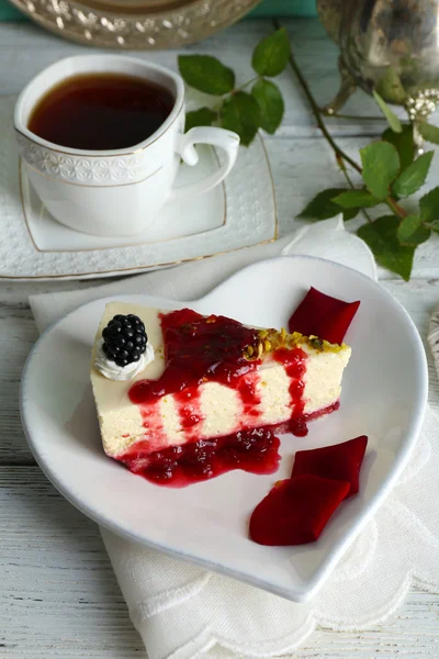 Lekker stukje cheesecake met berry saus op plaat op tafel close-up — Stockfoto