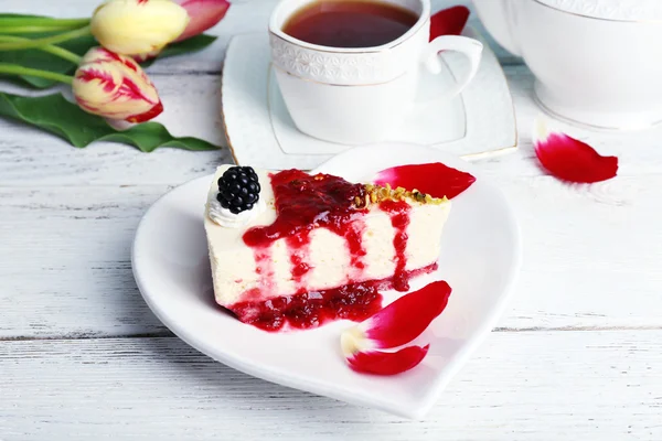 Lekker stukje cheesecake met berry saus op plaat op tafel close-up — Stockfoto