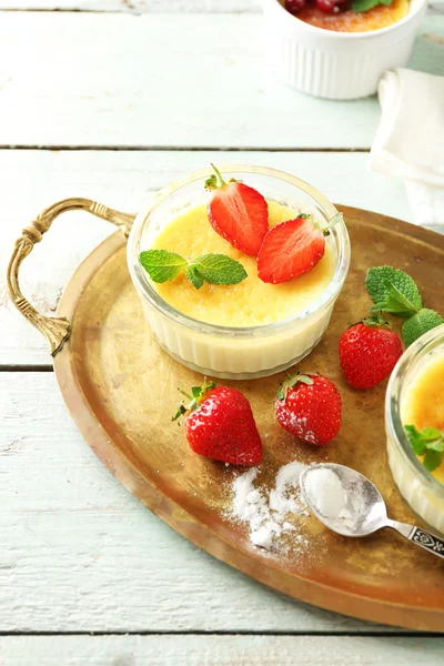 Crema brulee dessert con fragole fresche e foglie di menta, su sfondo di legno di colore — Foto Stock