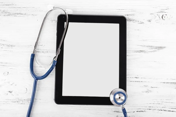 Tablet PC- en blauw stethoscoop op houten achtergrond — Stockfoto