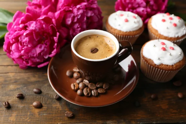 Composition avec tasse de café, muffins et fleurs de pivoine sur fond de bois — Photo