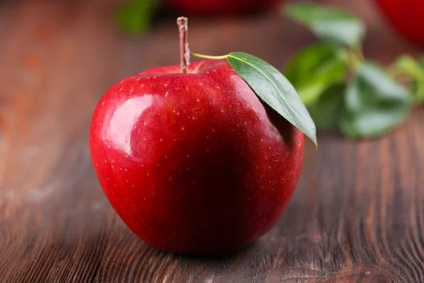 Red apple on wooden table, closeup — Stock Photo, Image