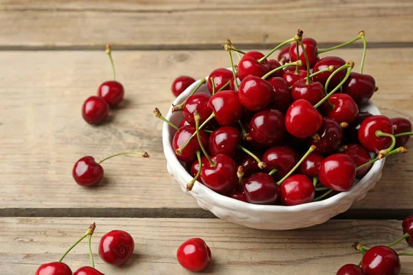 Sweet cherries in bowl on wooden table close up — Stock Photo, Image