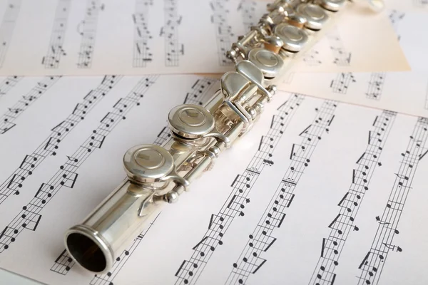 Flauta sobre fondo de notas musicales — Foto de Stock