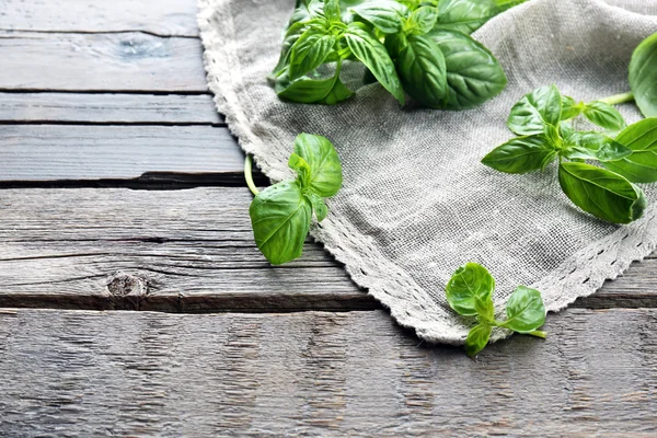 Green fresh basil with napkin on table close up — Stock Photo, Image