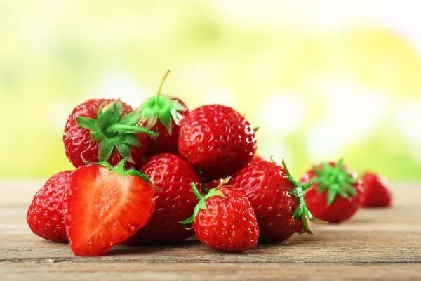 Ripe strawberries on wooden table on blurred background — Stock Photo, Image