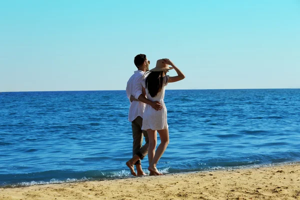 Jeune couple marchant sur la plage — Photo