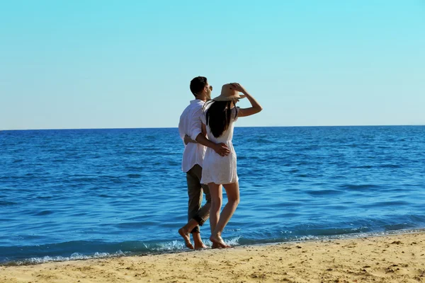 Pareja joven caminando en la playa — Foto de Stock