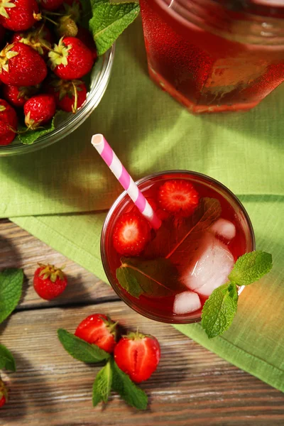 Full jug and glass of strawberry juice with berries on table close up — Stock Photo, Image