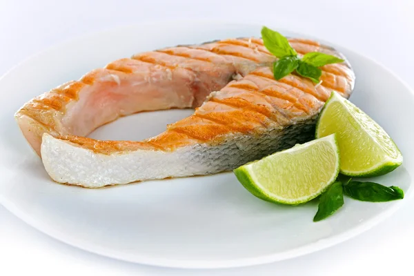 Tasty grilled salmon with lime on plate close up — Stock Photo, Image