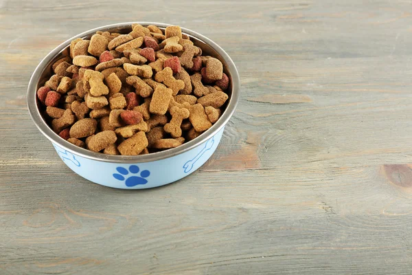 Comida para perros en tazón sobre mesa de madera — Foto de Stock