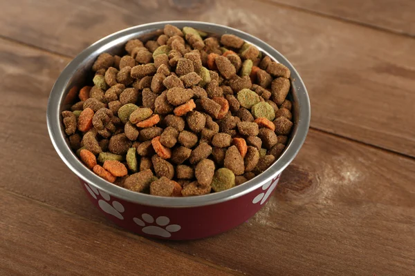 Comida para perros en tazón sobre mesa de madera — Foto de Stock