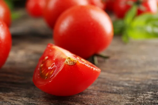 Tomates cherry con albahaca sobre mesa de madera de cerca — Foto de Stock