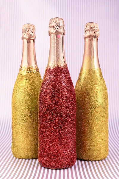 Ljusa flaskor champagne på papper bakgrund — Stockfoto