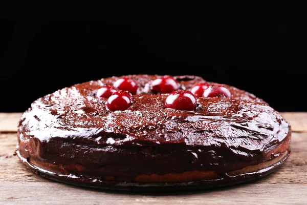 Смачний шоколадний торт з вишнею на дерев'яному столі на темному фоні — стокове фото