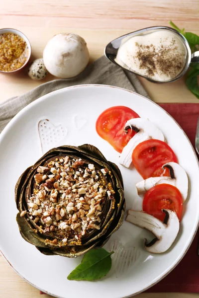 Vegetarian stuffed artichoke on plate, on table background — Stock Photo, Image