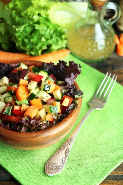 Деревянная чаша свежего овощного салата на салфетке, крупным планом — стоковое фото
