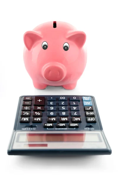 Piggy bank met calculator geïsoleerd op wit Rechtenvrije Stockafbeeldingen