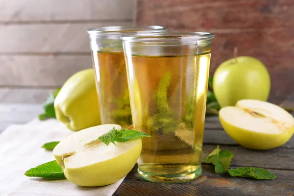Glasses of apple juice on wooden background — Stock Photo, Image